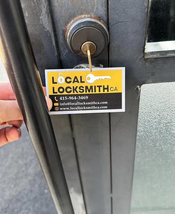 Deadbolt and Local Locksmith CA card on a gray door