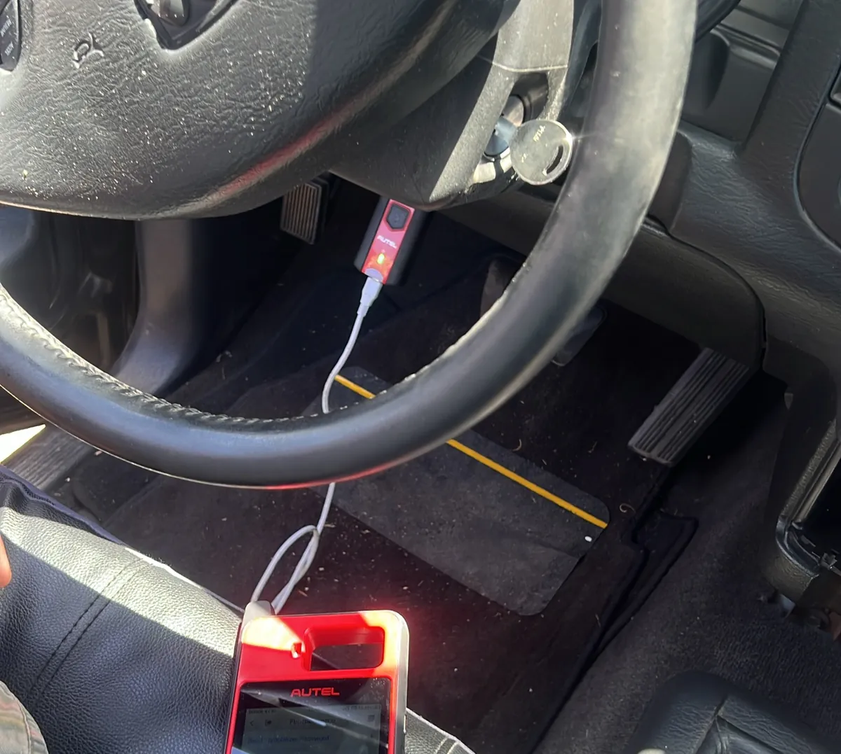 Key programmer connected to a Dodge van in a lot
