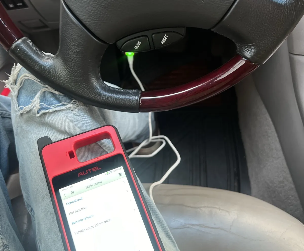 Key programmer plugged into a Lexus with the driver door open