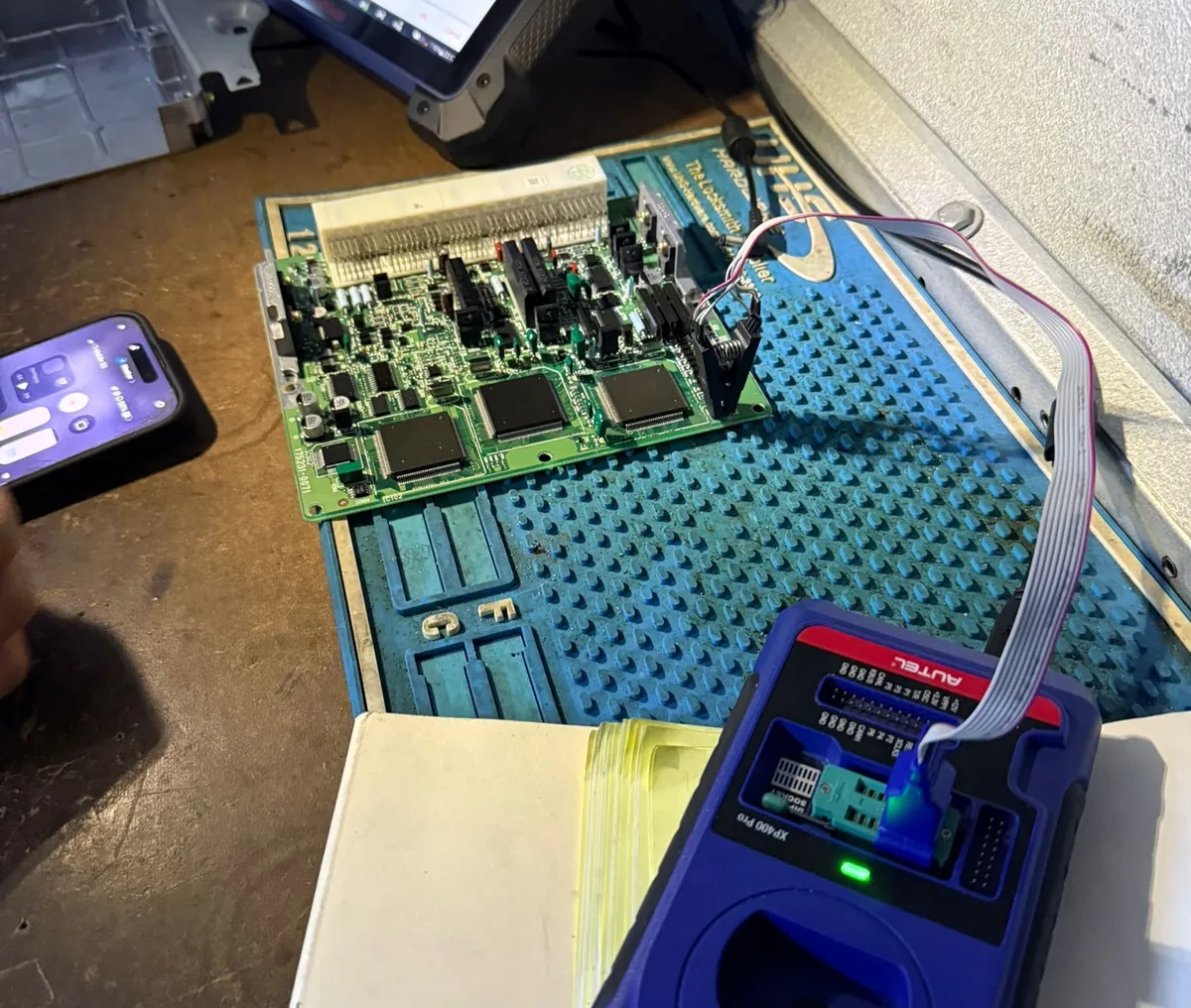 Car module opened on the bench and connected to a programmer